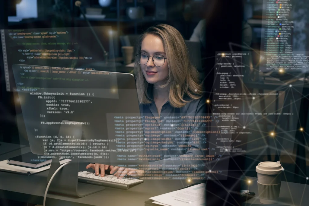 Une femme travaille sur un ordinateur affichant du code à l'écran.